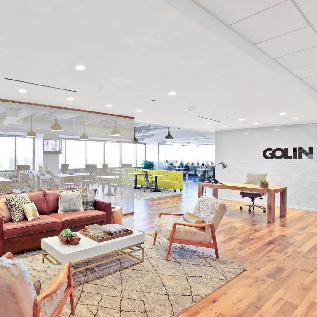 Golin Dallas lobby with leather couch and chairs and white brick wall with black Golin logo