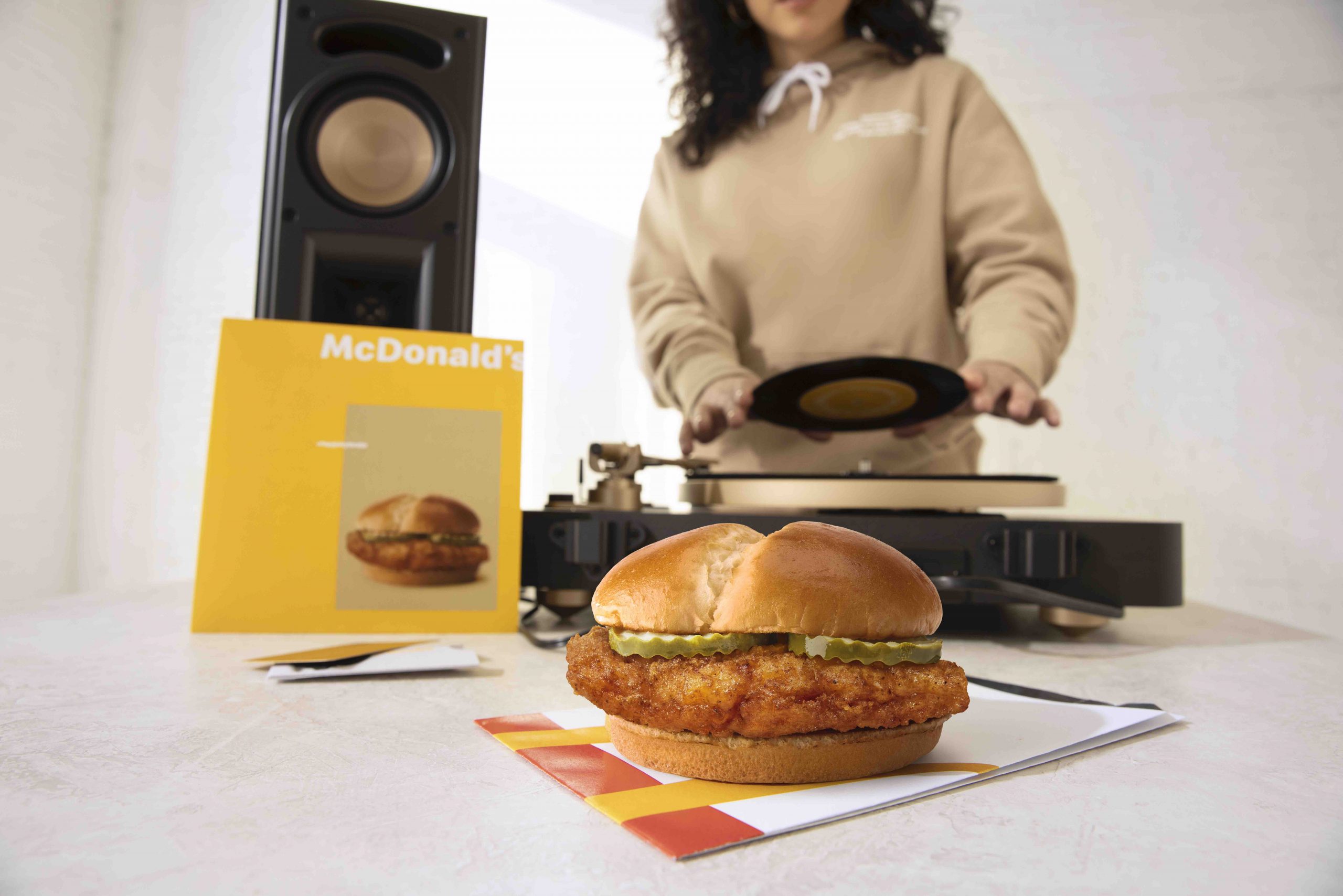McDonald's crispy chicken sandwich in front of a dj and other McDonald's swag