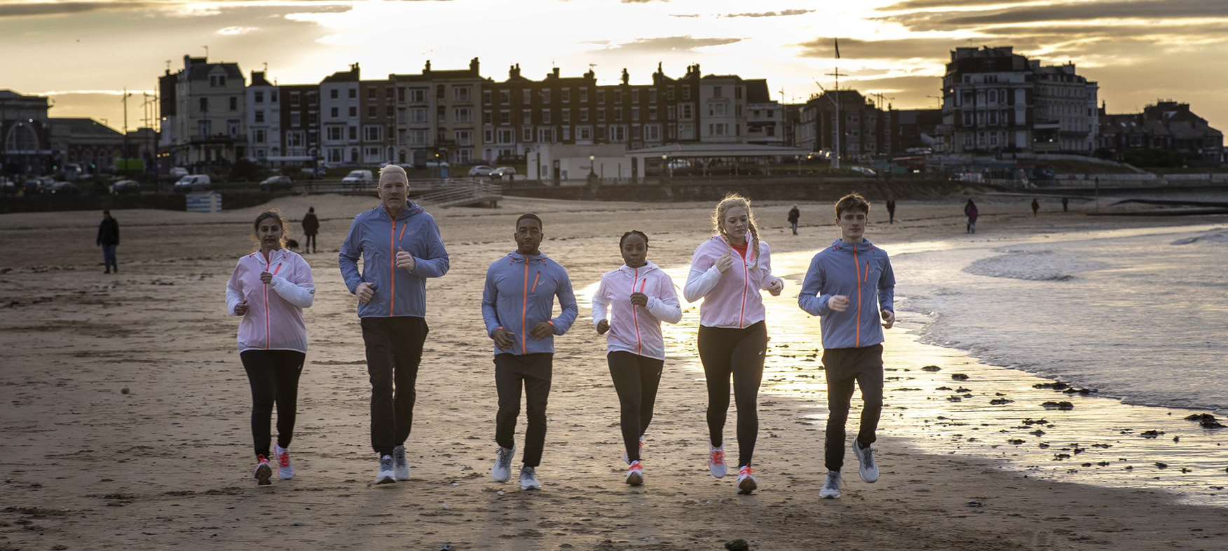 6 people jogging on a beach