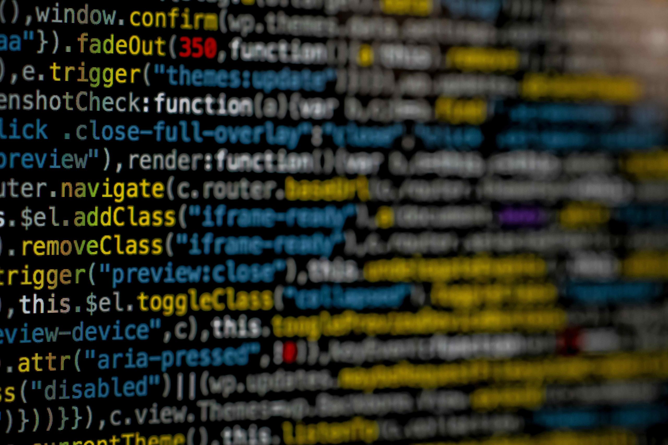 A close-up view of a computer screen displaying lines of colorful code. The focus is on a specific section in the center, where the text is sharp and clear, while the surrounding code is blurred due to a shallow depth of field.