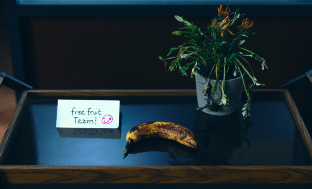 single rotting banana on a tray with a sign that reads 